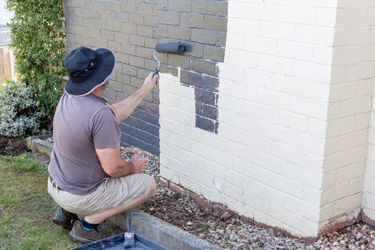 Senior man painting the exterior of a brick suburban home, How Long Does Paint Last On Brick?