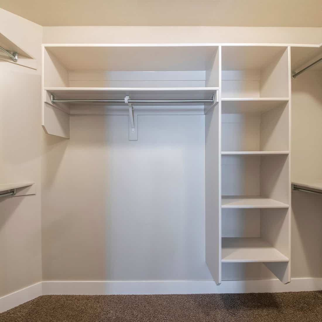 Square frame interior of a small walk-in closet with carpeted floor 