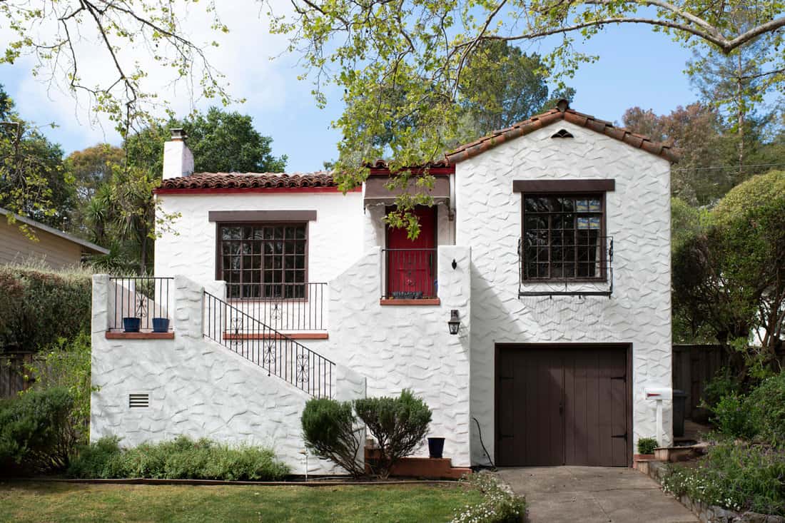 Two Story White Stucco House with Stairs and a Red Door