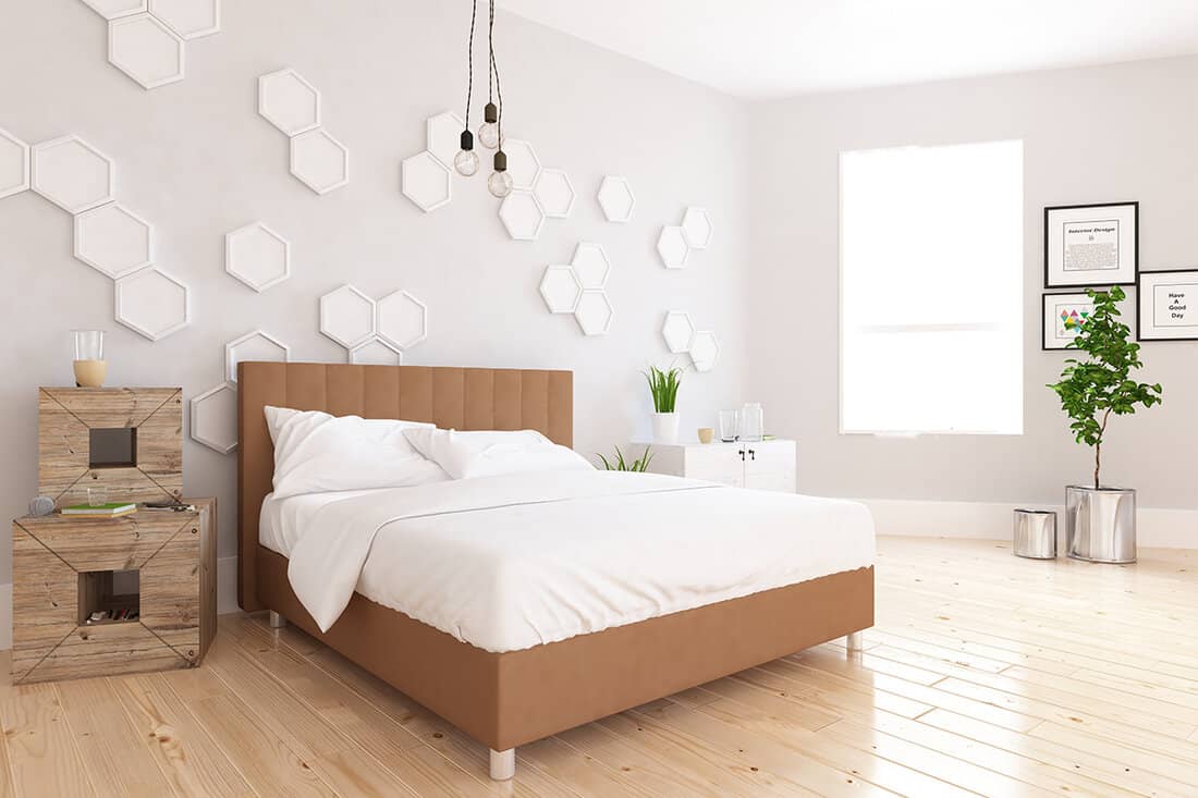 White scandinavian bedroom interior with large beige bed with decor on large wall