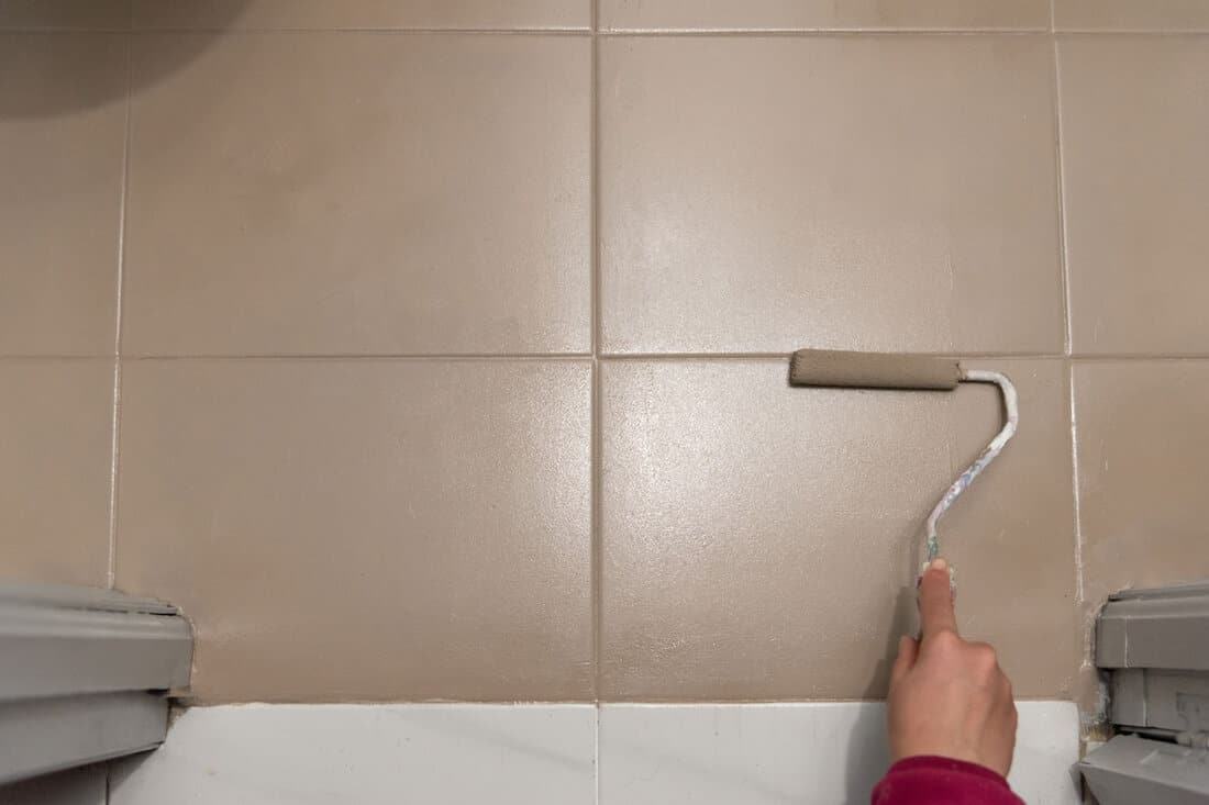 human hand holding paint roller over