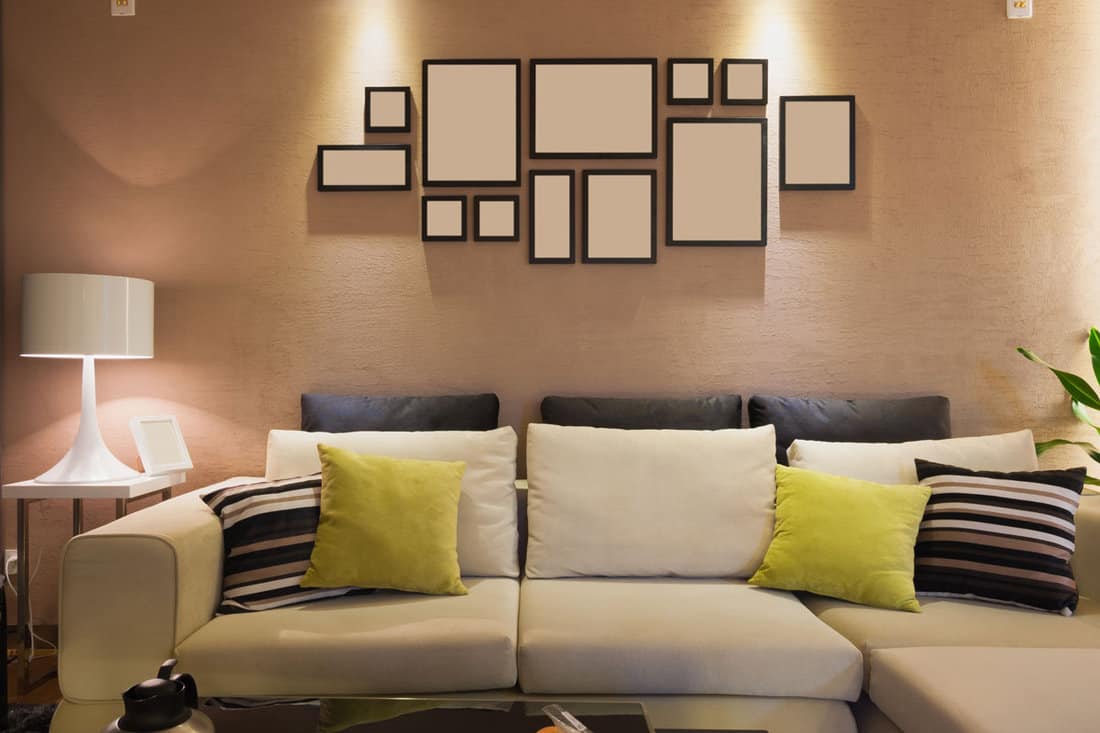 modern living room with frames in the wall and a beige type of color scheme