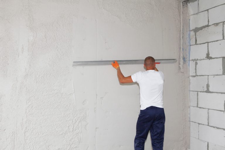 A handyman, building contractor is skim coating, finishing, plastering the drywall making the wall smooth with a broad, large skimming blade, knock-down knife during house renovation., Do I need to skim-coat drywall before priming?