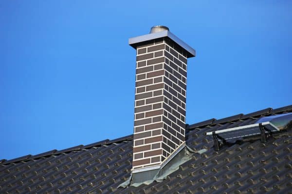Chimney clad with clinker bricks on a newly covered roof, Should You Paint Your Exterior Cinder Block Chimney