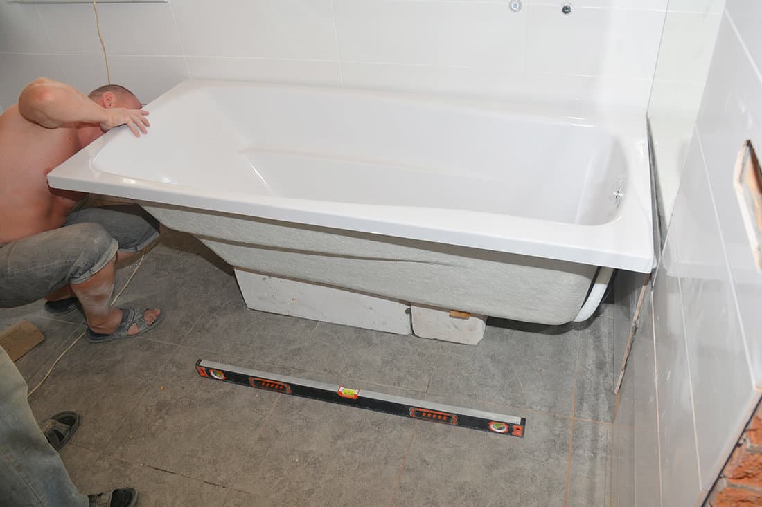 Contractors removing bathtub in house bath room
