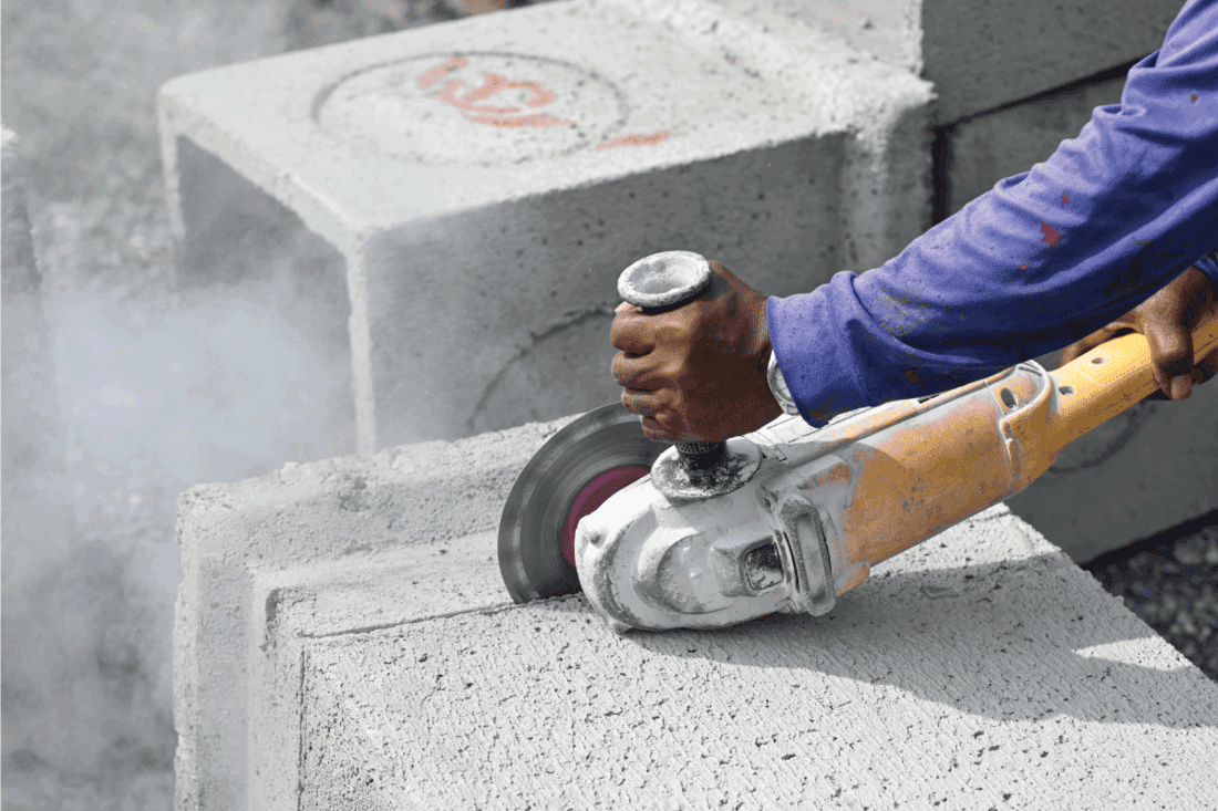 Industrial construction worker using a professional angle grinder cutting the concrete Block. How To Cut A Concrete Block Without A Saw