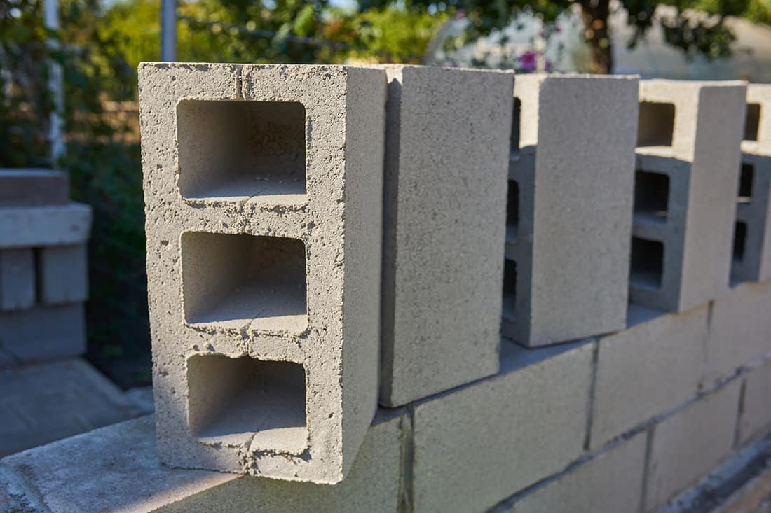 Worker builds a cinder block wall for a new home