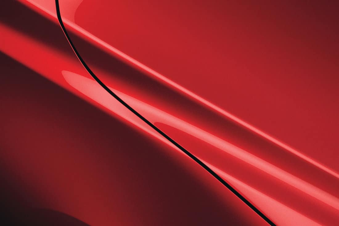 close up car detail red glossy metallic car paint