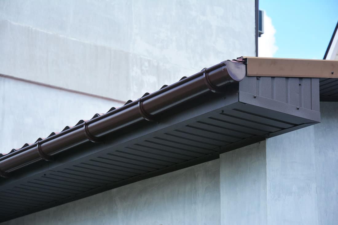 house plastic roof gutter with soffit and fascia board.