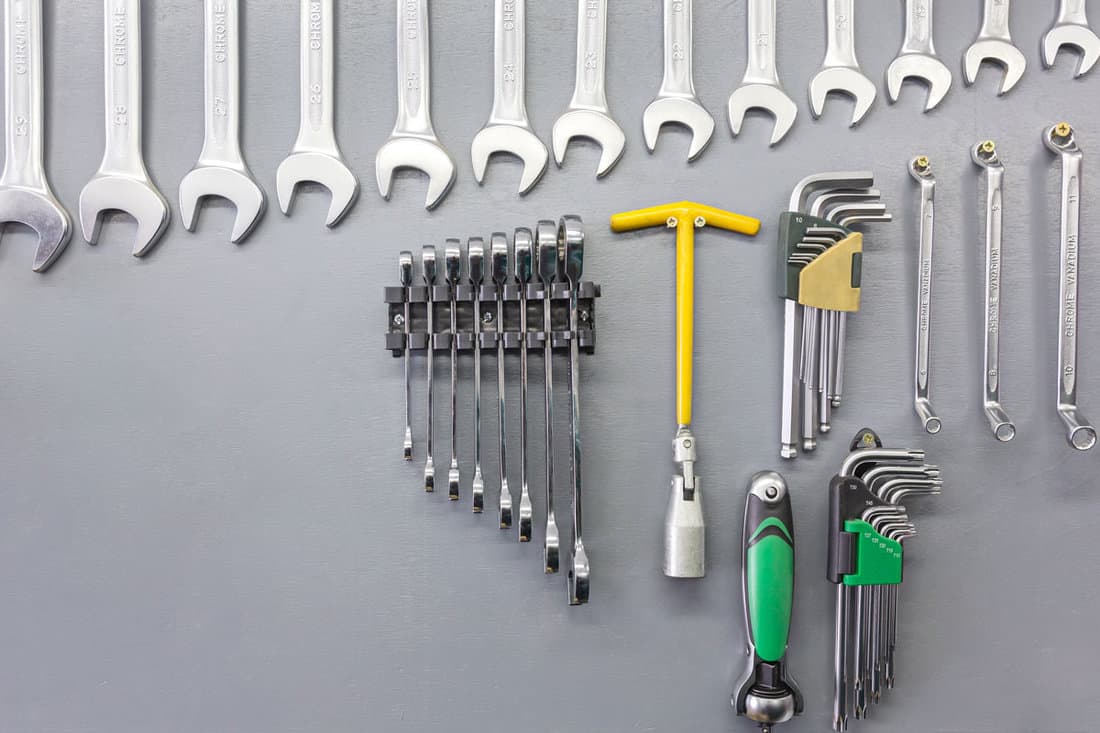 set hand tools on grey wooden wall