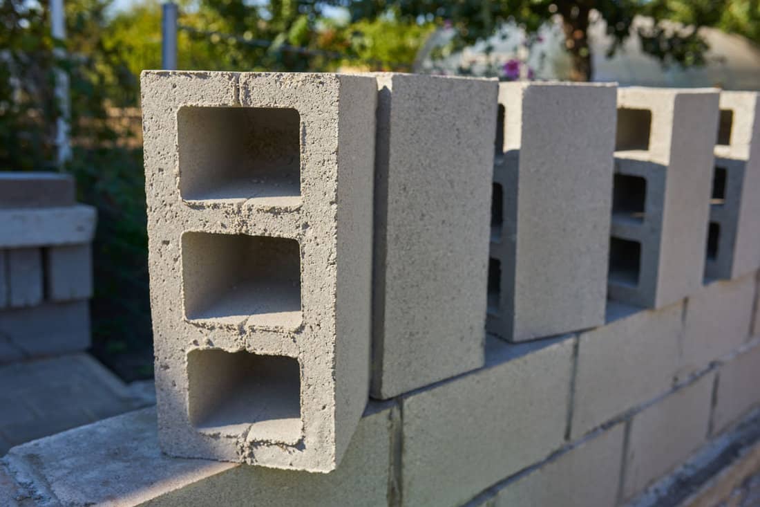 worker builds cinder block wall new house building