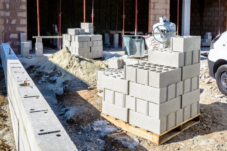 Cinder block piled outside a house undergoing construction, How To Run Pipe Through Cinder Block