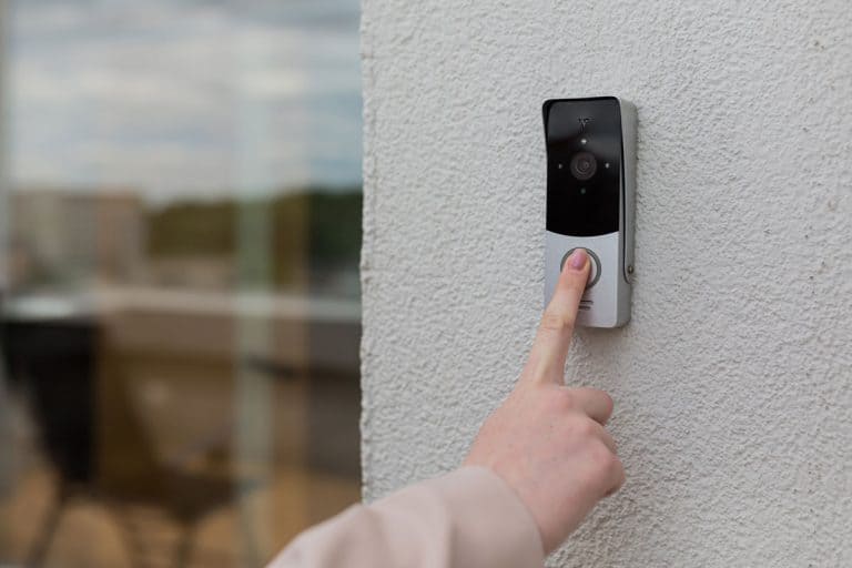 Woman pressing the door bell for the office, How To Remove A Wyze Doorbell