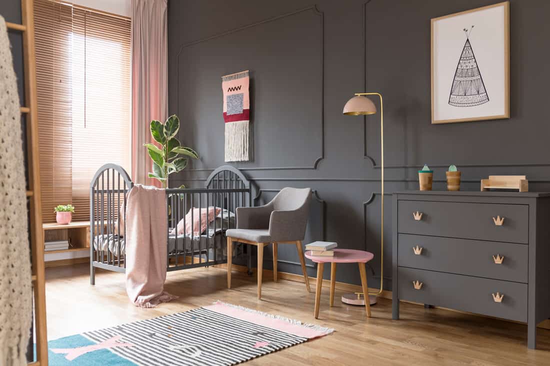 Interior of a huge childs room with gray painted walls and a gray crib