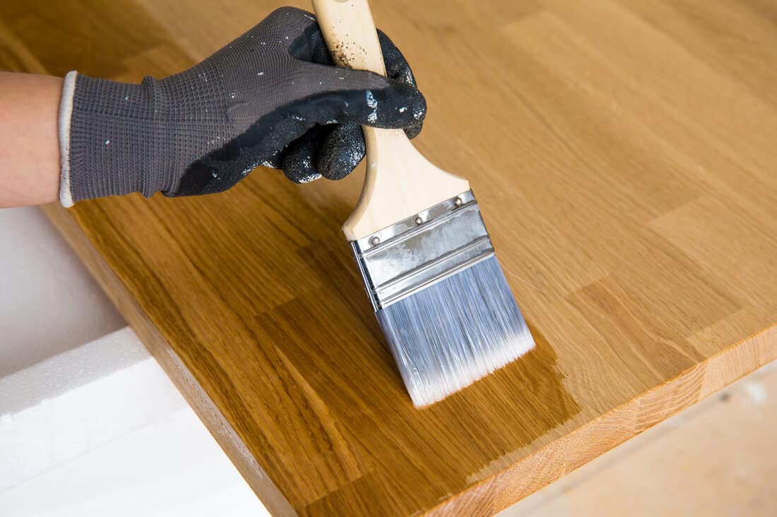 Person working, oiling kitchen countertop before using, brushing oiling with linseed oil.