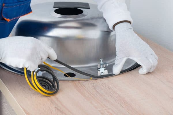 a specialist in protective clothing, glues a sealing tape to eliminate moisture between the countertop and the metal sink, Should You Seal Bathroom Countertops?