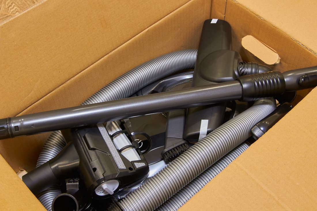 new vacuum cleaner in the box,an open cardboard box with a vacuum cleaner, a vacuum cleaner for cleaning