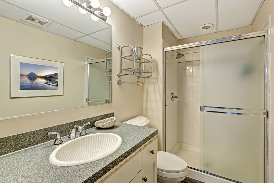 Bathroom vanity cabinet with granite top and shower with slide glass door