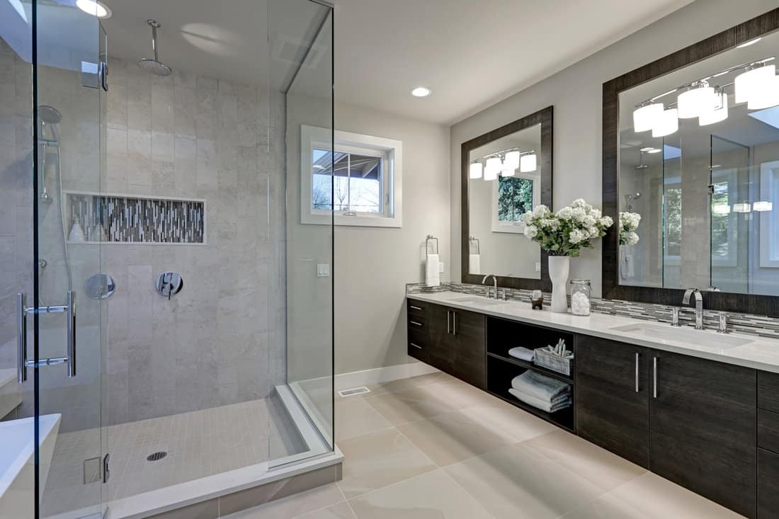 Spacious bathroom in gray tones with heated floors, walk-in shower, double sink vanity and sky