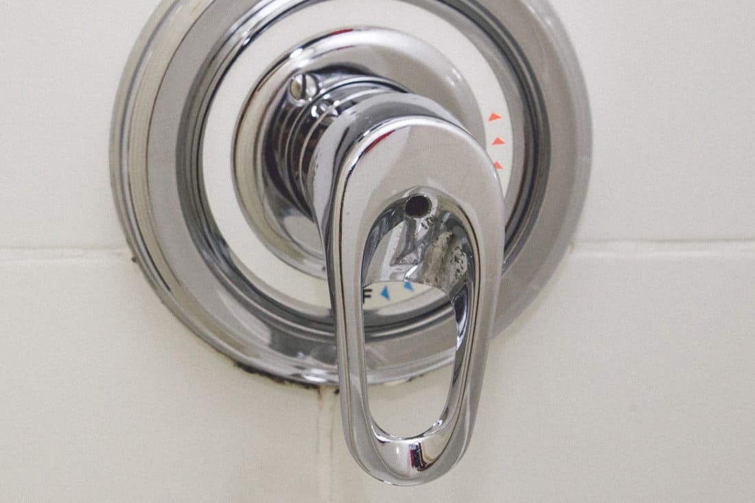 Bath control heat or cold , drops water on the shower valve handle isolated