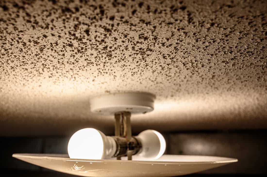 popcorn textured ceiling with LED bulb light fixture and glass cover