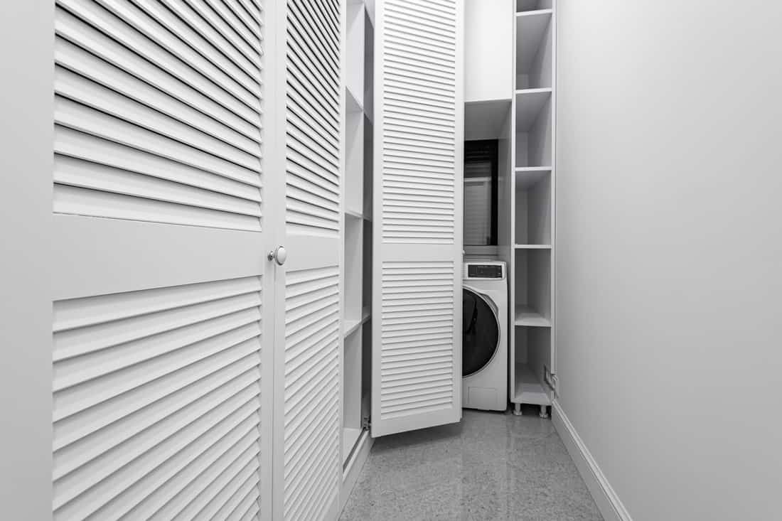 An opened closet in the master closet with a washing machine and dryer