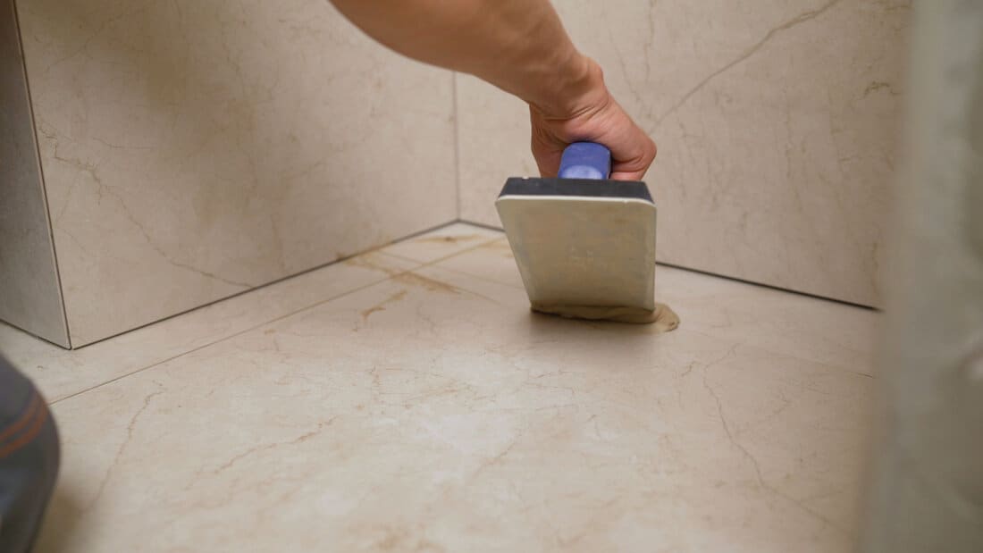 hand wiping interlayer tabs with putty grout