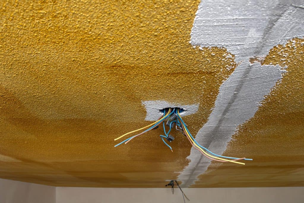 An image depicts the process of applying mud over a popcorn ceiling, altering its texture.
