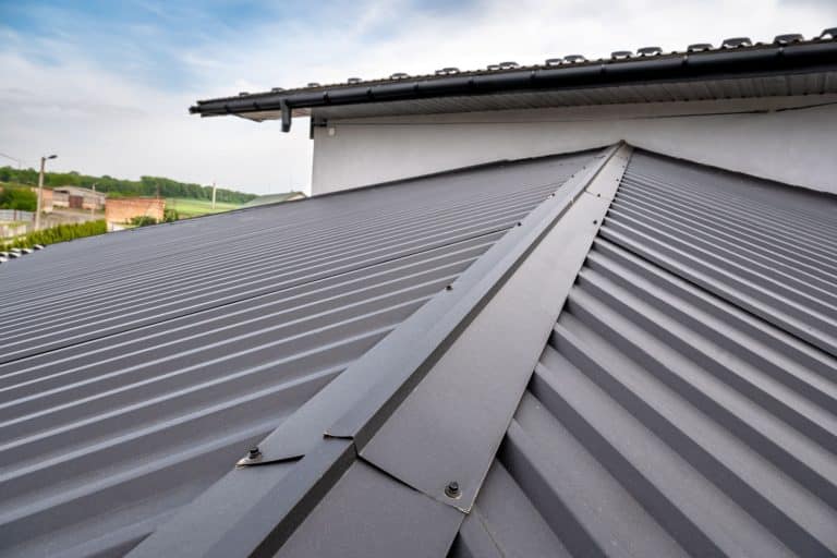 Presenting a house featuring a gutter system designed for a metal roof, including a roof-mounted gutter drainage system. The house showcases a metal roof with an exceptionally sleek and straight design. - How to Keep a Metal Roof Straight