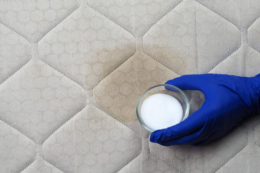 Hand cleaning surface of mattress with baking soda. Ecological cleaning and disinfection of surfaces.