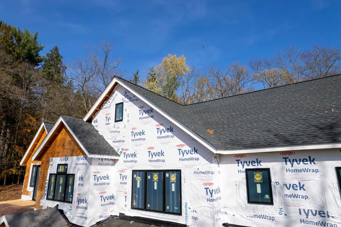 The exterior of a residential property draped in Tyvek house wrap.


