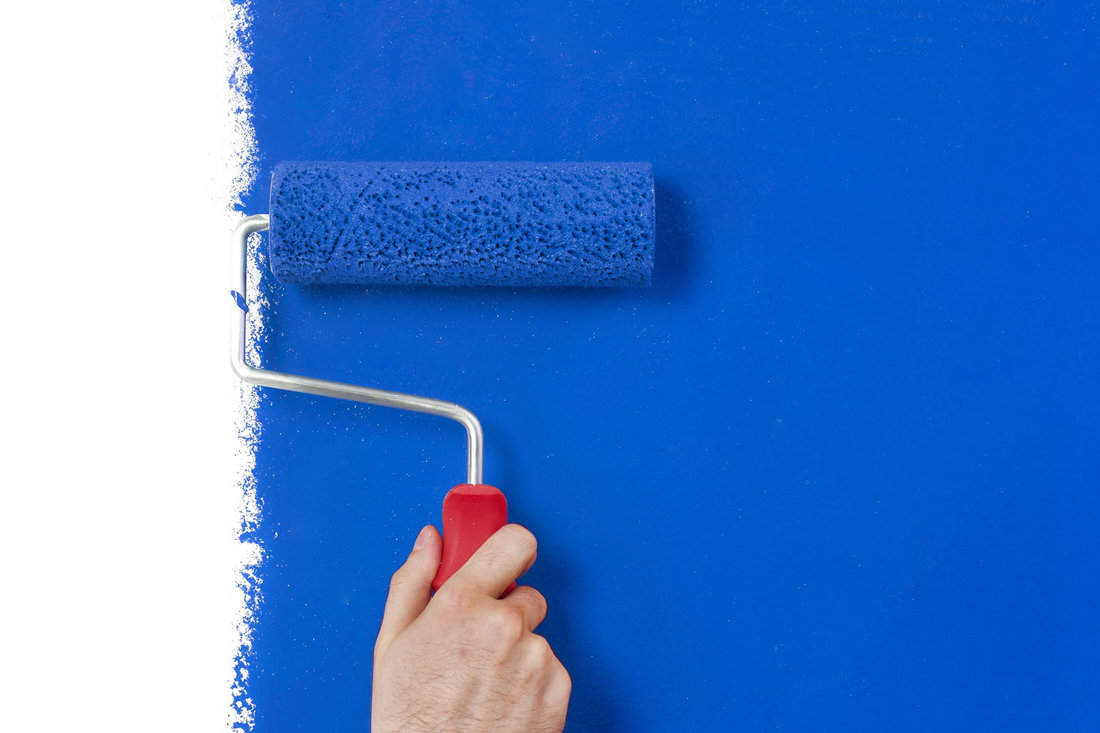Man painting the wall with blue color