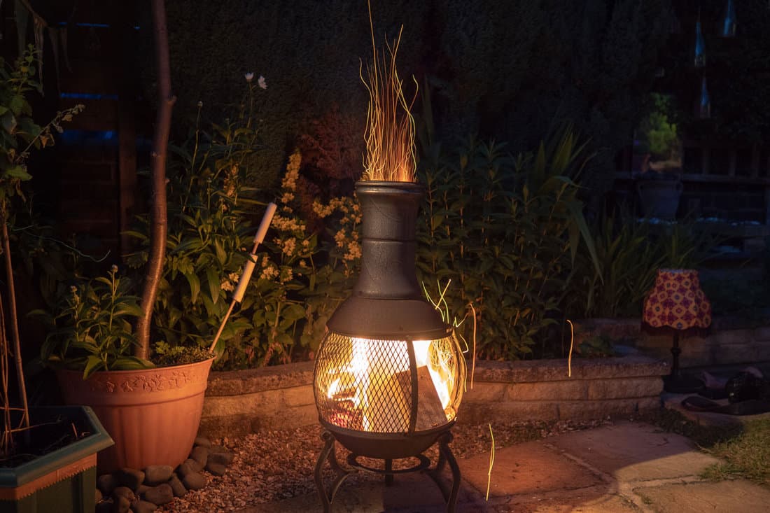 A chiminea burning bright flame at the backyard garden
