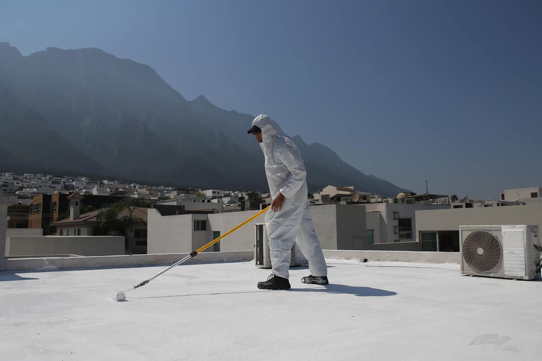 Worker applying Elastomeric Roof Coating