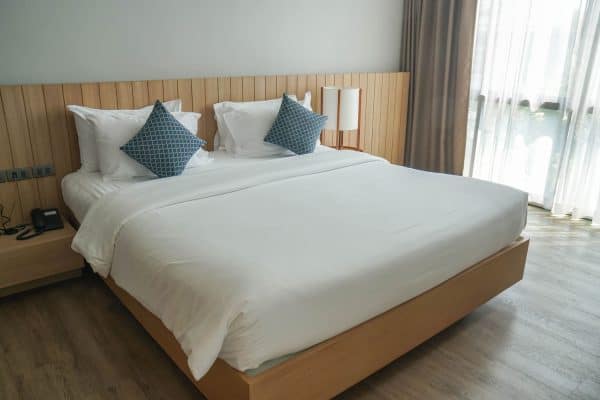 Bedroom with white beddings and a wooden framed bed