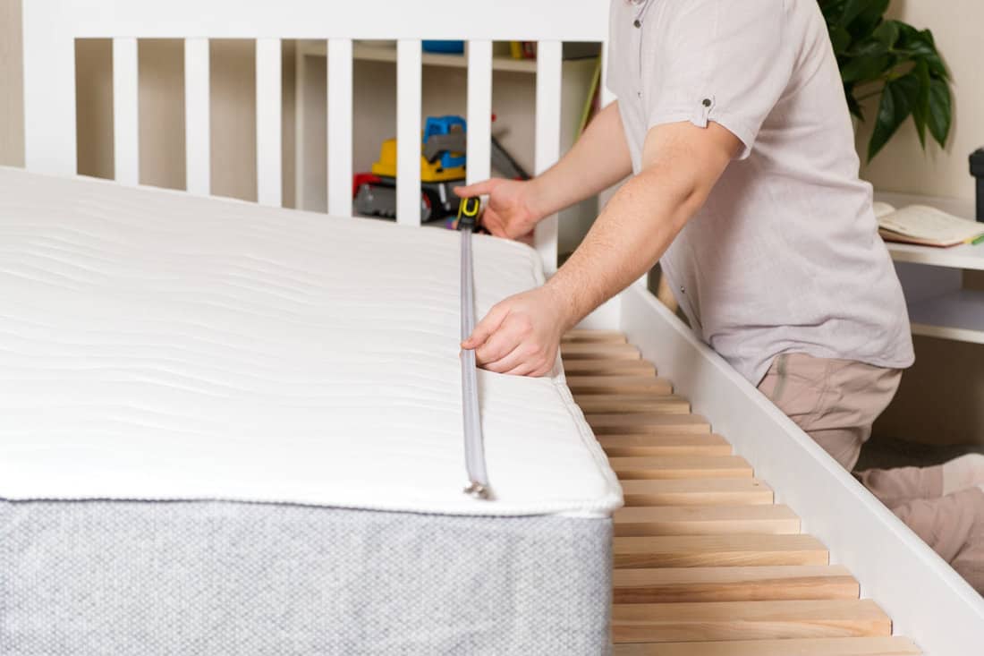 Man measuring bed