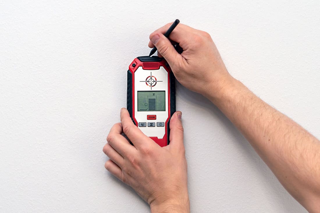 Worker using a stud finder on the wall