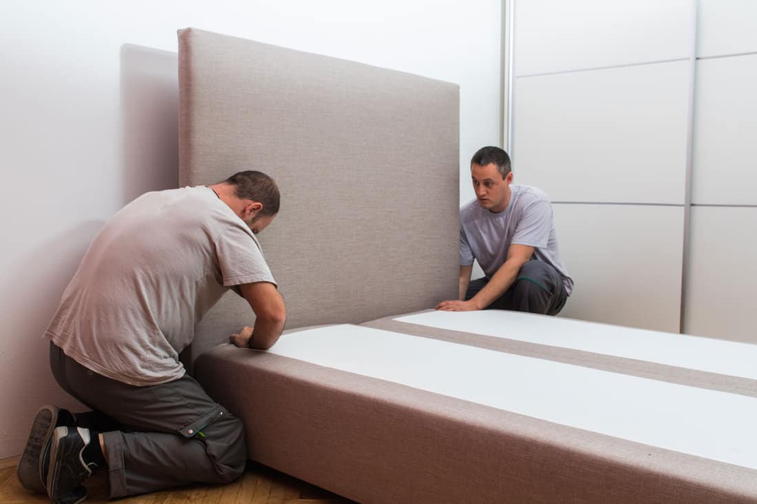Two people installing a bed