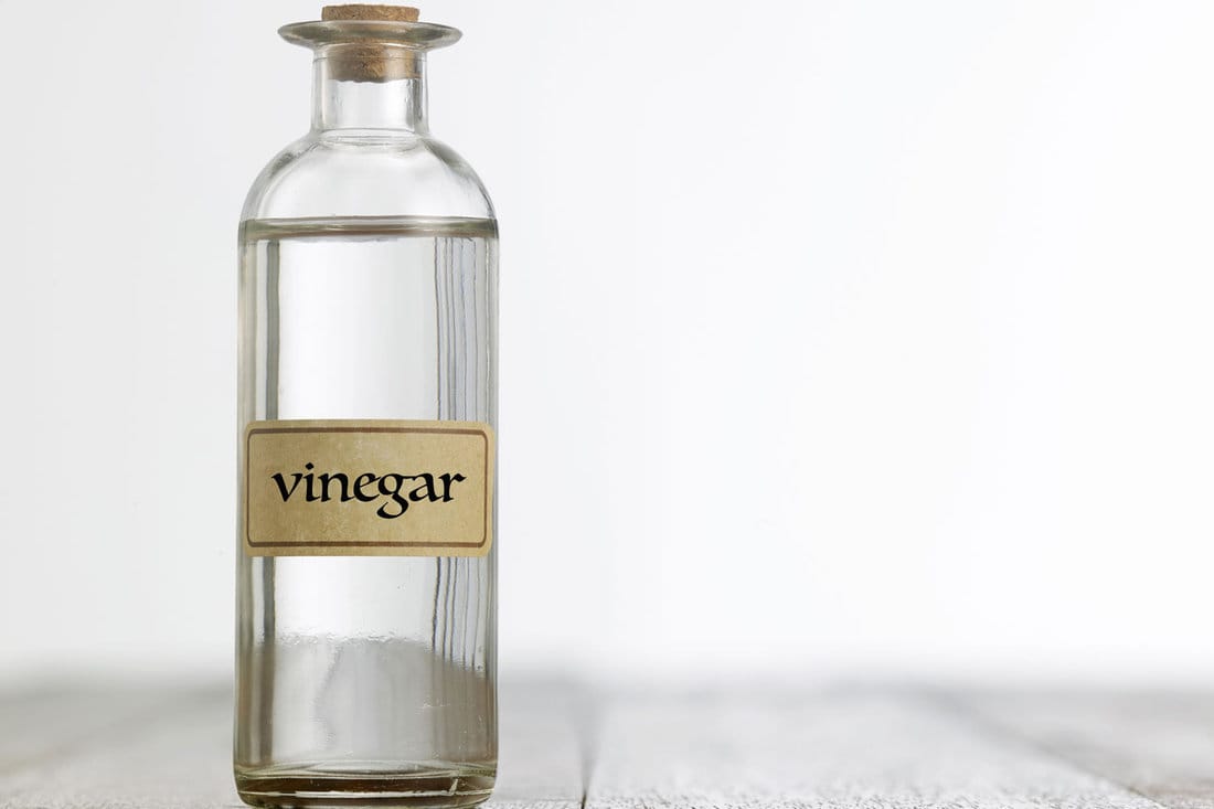 white vinegar on the wooden table top
