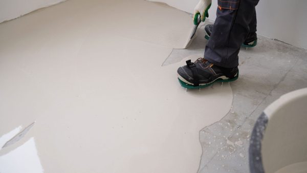 Worker applying self leveling epoxyepoxy to the , Can You Put Epoxy Over Self-Leveling Concrete? - 1600x900