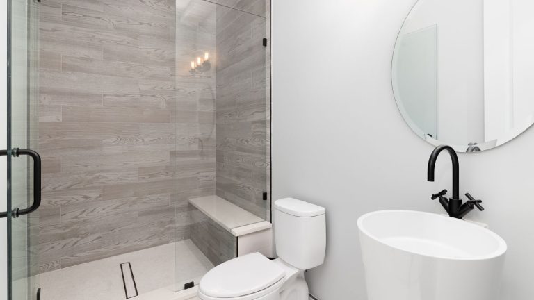 Interior of modern bathroom with glass shower walls. Does A Shower Bench Need To Be Sloped? Quick Answers for Easy Setup - 1600x900