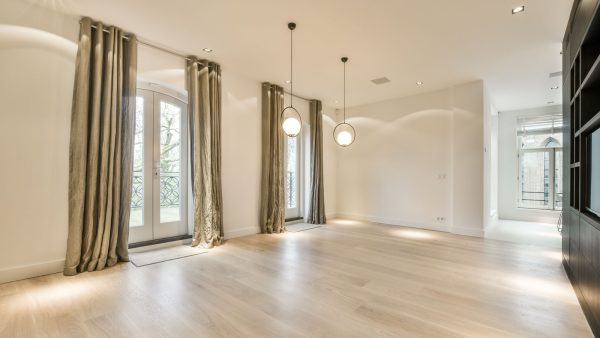 Interior of an empty living room with brown curtains, How Many Inches Should Curtains Puddle? - 1600x900