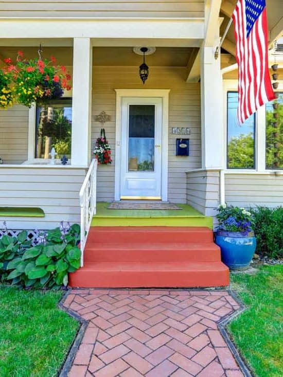 Front porch of a rustic type house with the american flag hanged in front