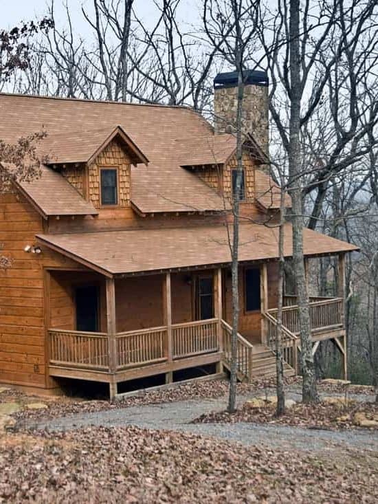 House in the middle of the woods made with wooden front porch up to the roof