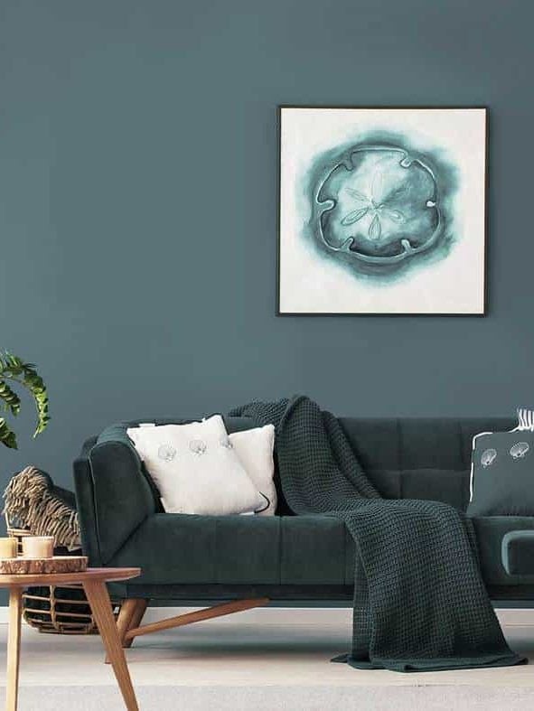 Poster above sofa with pillows in modern living room interior with wooden table and plant