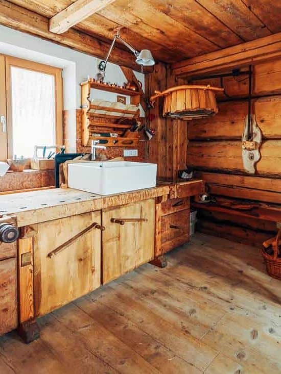 Gorgeous primitive farmhouse kitchen with bold wood cabinets and an iron furnace