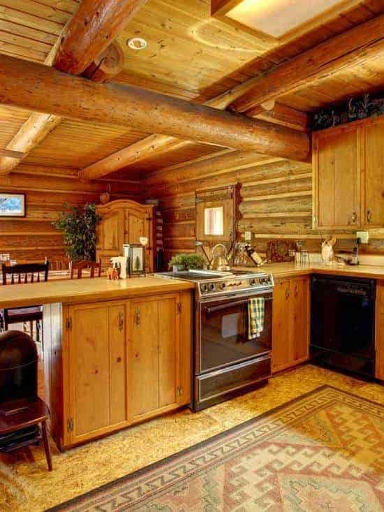 Wood cabin rustic kitchen interior with oak beams and stone flooring