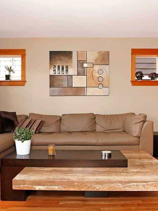 Beautiful modern living room interior with brown leather sofa, wall art decor, parquet floor and glass window