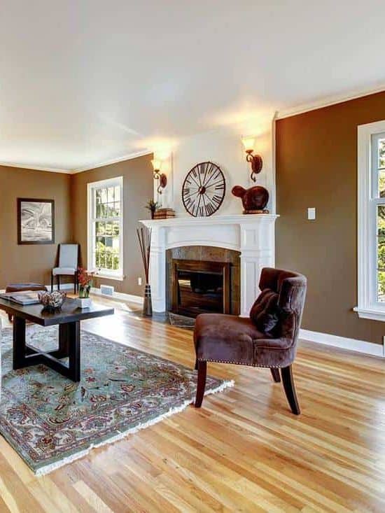 Classic brown and white living room interior with hardwood floor, fireplace and wall poster
