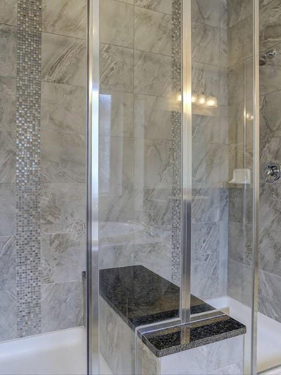 Contemporary double-shower with marble tiles and bench seat